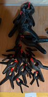 Group of assorted size black plastic clamps with red pads