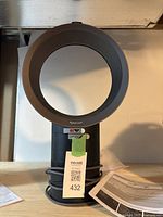 Front view of Dyson Cool desk fan with loop and base visible, manual partly shown