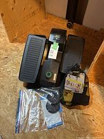 Top view of under-desk elliptical showing pedals, display, resistance knob and bundled accessories