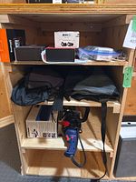 Shelf showing boxed golf electronics, covers and Simoniz polisher