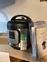 Instant Pot pressure cooker with manual and recipe booklet