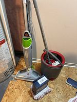 Steam mop, spin mop with bucket and boxed pad kit grouped together