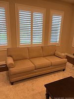 Front view of beige 3-seat Barrymore sofa below windows