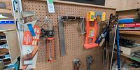 Overall pegboard with various saws, caulking gun, pipe wrenches