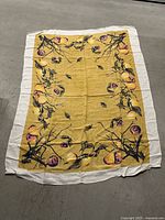 Full view of fruit motif tablecloth with mustard background and white border