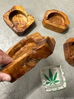 Group view of four wooden ashtrays and one glass ashtray