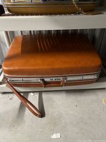 Closed suitcase showing exterior color, texture, and pull strap