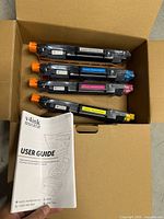 Open box showing four v4ink toner cartridges and user guide