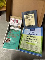 All four self-help items laid out: two books, two audiobook CD sets