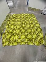 Full view of green floral quilted bedspread spread out