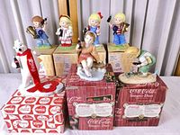 Group shot of all seven Coca-Cola figurines with boxes