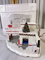 Front angled view of lighted service center sculpture showing overall design and snow base