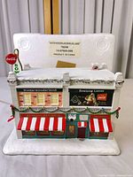 Front view of illuminated bowling lanes building with Coca-Cola signage and storage Styrofoam behind