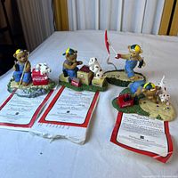 Four bear figurines with certificates on table