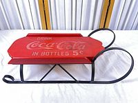 Full side view of red wood Coca-Cola deck and black metal runners