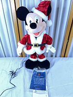 Full view of Mickey Mouse Santa figure on base with power cord and instructions bag