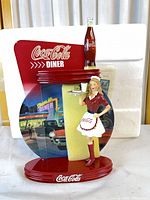 Front view of Coca-Cola diner decorative plate with waitress figure and bottle accent