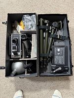 Open hard case showing camera, tripod, flash, accessories