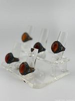 Five rings displayed on acrylic stand showing enamel work and cabochon stones