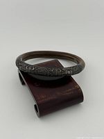 Top view of entire silver bangle showing raised symbols and patina