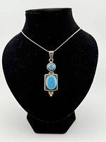 Necklace displayed on bust showing pendant and chain