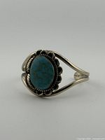 Front three-quarter view of silver cuff showing turquoise stone and split-shank design