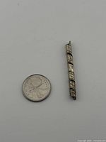 Pendant beside coin for size reference