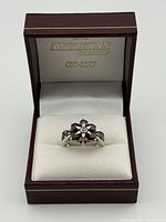 Ring in Augustian box front view showing garnet flower design