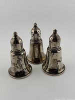 Front view of three sterling salt shakers