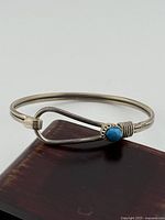 Full view of sterling silver bangle showing turquoise cabochon and clasp