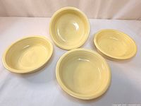 Four yellow Fiesta bowls top view