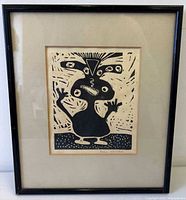 Front view of framed linocut showing artwork, mat and black frame