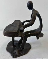 Front view of bronze sculpture showing pianist and keyboard