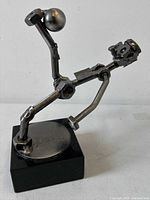 Front view of welded steel soccer player sculpture on black marble base