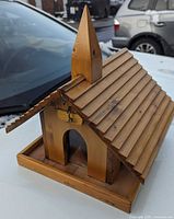 Front angled view showing pine church birdhouse with steeple and tray base