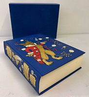 Book on side showing front board artwork and slipcase