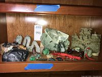 Shelf of assorted carved stone figurines and plaques