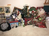 Wide view full lot on floor including ornaments, pillow, tree, figures, garland, bags