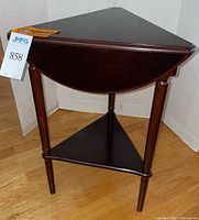 Table in triangular configuration, leaves folded, showing lower shelf