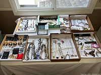 Overview of all jewellery laid out in trays on table