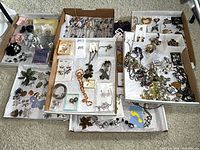 Overhead view of multiple trays filled with assorted costume jewelry pieces