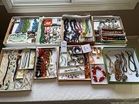 Six trays filled with assorted bead and pearl jewelry strands and loose findings