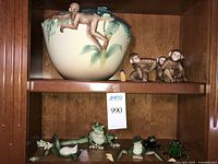 overall shelf view showing bowl with monkey, three small monkeys and frog figurines