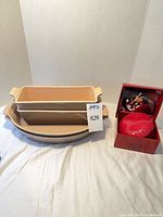 Entire lot: two stacked loaf pans, two oval bakers beneath, red brie baker in box