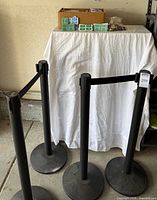 Four Queue Way stanchions with cardboard box of ticket rolls on table