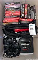 Overall lot showing Genesis console, controllers, 14 boxed games, carry bag and red Game Gear