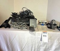 All items laid out: camcorder, bag, cables, tape, remote, battery, manual