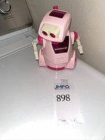 Front view of pink Tomy Sucharaka Bot robot toy on flat surface