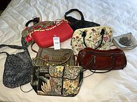 All ten handbags displayed on bed