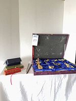 Full lot: open presentation case with 12 crystal zodiac figurines, additional boxes and stir sticks